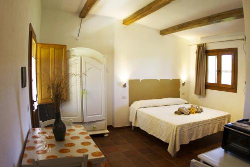 una camera da letto con due letti e un tavolo di La Casa Del Poeta a Aglientu