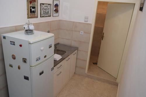Apartment Monika في كوتور: مطبخ صغير مع ثلاجة بيضاء ومرآة