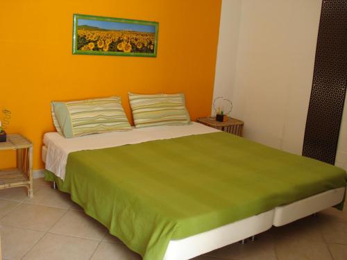 a bedroom with a large bed with an orange wall at Breezes B&B in Conca Specchiulla
