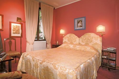a bedroom with a bed in a red room at Locanda San Vigilio in Garda
