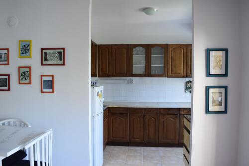 a kitchen with wooden cabinets and a white refrigerator at Two bedroom apartment near centre in Ohrid