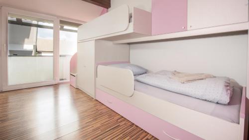 a bedroom with a bunk bed with pink cabinets at Boomerang Apartment Bled in Bled