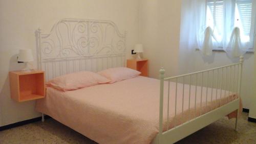 uma cama branca com almofadas cor-de-rosa num quarto em Il Martello em Finale Ligure