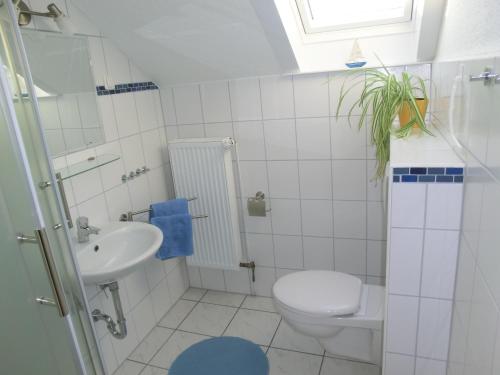 ドゥネンにあるHaus Strandgut/1の白いバスルーム(トイレ、シンク付)
