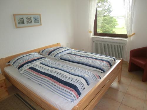 una cama con una manta a rayas encima en Haus Strandgut/1, en Duhnen