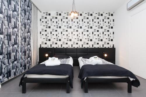 - 2 lits dans une chambre revêtue de carrelage noir et blanc dans l'établissement New York 2 pièces 3 étoiles calme plein centre de cannes, 5mn des plages et Palais, à Cannes