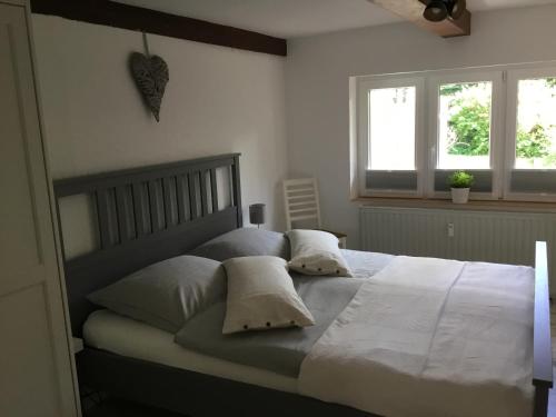 a bedroom with a large bed with white sheets and pillows at Erholung unter Reet in Bordelum