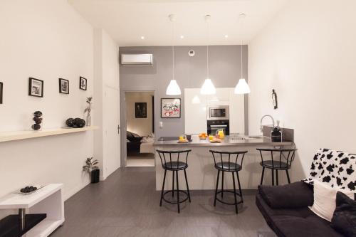 une cuisine et un salon avec un bar dans une pièce dans l'établissement Charlie Chaplin 2 pièces 3 étoiles calme plein centre de Cannes, 5mn des plages et Palais, à Cannes
