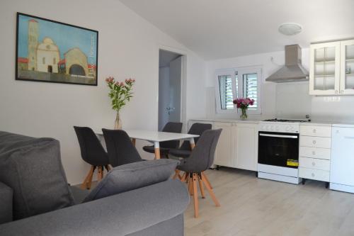 Il comprend une cuisine et un salon avec une table et des chaises. dans l'établissement Apartments Basina, à Vrbanj