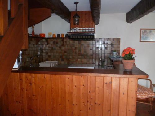 una cocina con encimera con fregadero y barra de sidx sidx en P'ty gîte de Bréharadec, en Goulien
