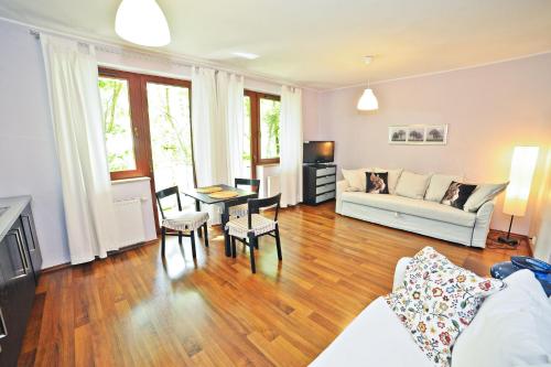 uma sala de estar com um sofá e uma mesa em Grand Apartments Duet em Sopot