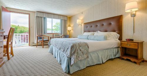 a hotel room with a large bed and a balcony at Rhumb Line Resort in Kennebunkport