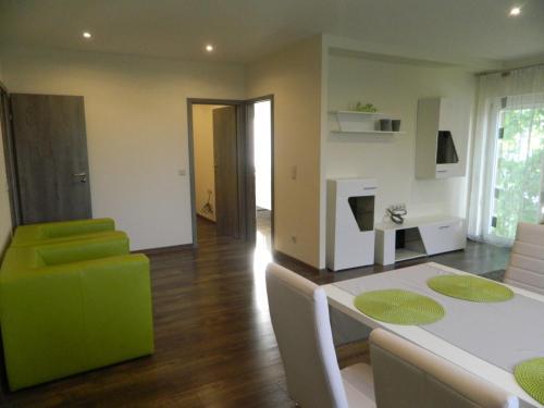 a living room with a green couch and a table at Greentó Apartman in Balatonföldvár