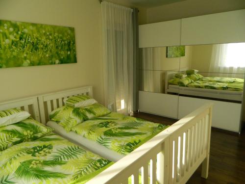 a bedroom with two twin beds and a mirror at Greentó Apartman in Balatonföldvár