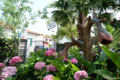a garden with pink flowers and a palm tree at Hotel Ambra in Forte dei Marmi