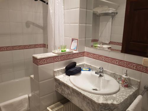 y baño con lavabo, espejo y bañera. en Pazo Vilabade en Vilabade