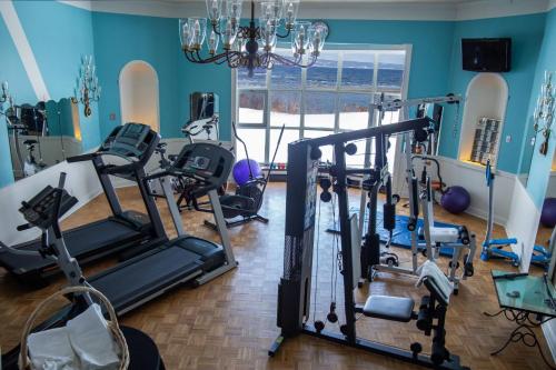 a gym with exercise equipment and a large window at Hôtel le Manoir Baie-Comeau in Baie-Comeau