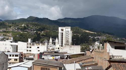 ロハにあるHostal Los Liriosの建物と山々を背景にした都市