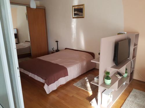 a small bedroom with a bed and a television at Mommy's House in Varna City