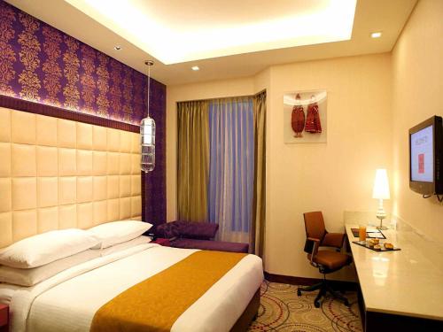 Pokój hotelowy z łóżkiem i biurkiem w obiekcie The Metropolitan Hotel & Spa New Delhi w Nowym Delhi