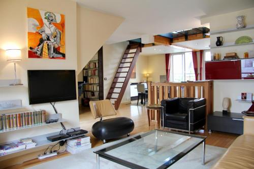 a living room with a glass table and a loft at Maison Lavaud in Paris