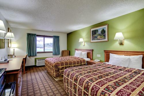 a hotel room with two beds and a television at Bloomer Inn & Suites in Bloomer