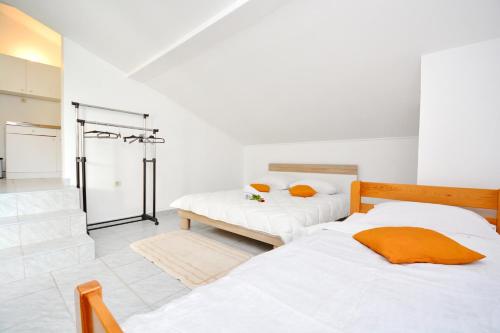 two beds in a room with white walls at Apartmani Maća in Sikovo