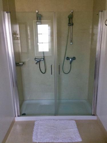 a bathroom with a shower with a glass door at Casa Maria Joana in Ponte de Lima