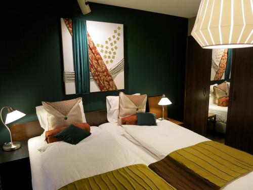 a bedroom with a large white bed with green walls at AH87 Osaka in Suita
