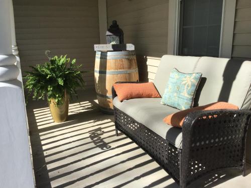 a wicker chair sitting on a porch with a plant at Old Town Country Landing in Niagara on the Lake