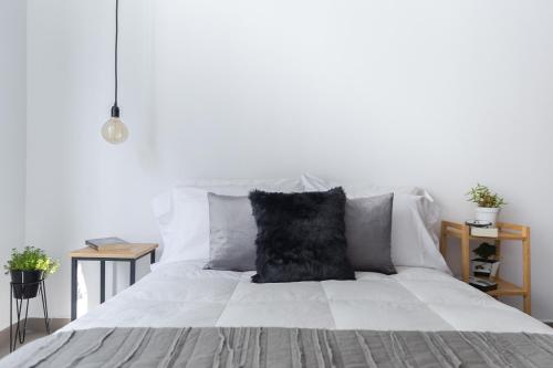 Una cama blanca con una almohada negra. en Immaculate Bucareli Apartment, en Ciudad de México