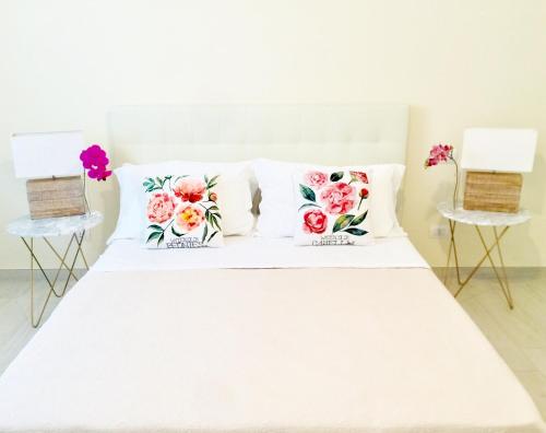 a white bed with three pillows on top of it at Flowers Sweet Rooms B&B in Vasto