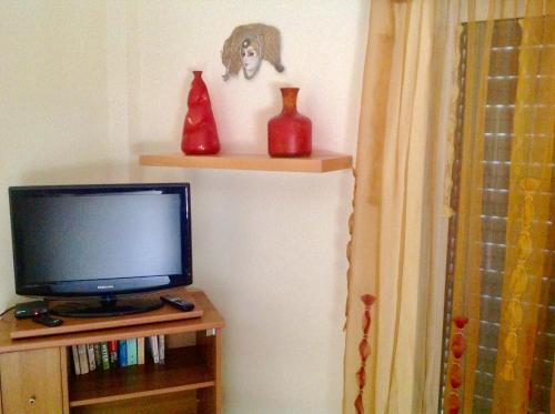 a television sitting on a shelf with vases on it at Villa Sofia in Chrani