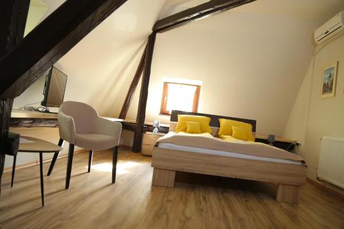 um quarto com uma cama com almofadas amarelas e uma secretária em Villa Ricz em Palić