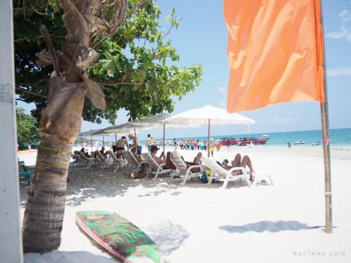 a group of people sitting in chairs on the beach at Nong Nuey Rooms in Ko Samed