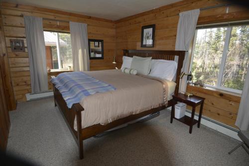 um quarto com uma cama num chalé de madeira em Antler's Rest Bed and Breakfast em Glennallen