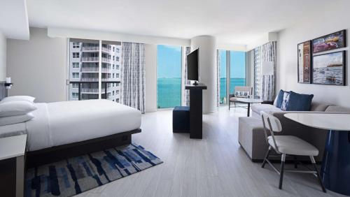 une chambre d'hôtel avec un lit et un salon dans l'établissement Hyatt Centric Brickell Miami, à Miami