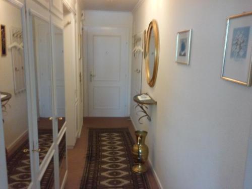 einen Flur mit weißen Wänden, einer weißen Tür und einer Treppe in der Unterkunft Apartment Seaside in Westerland