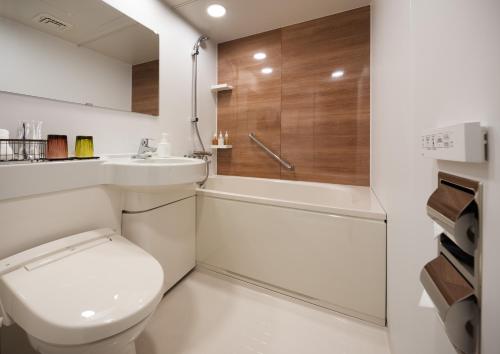 a bathroom with a toilet and a sink and a shower at Nest Hotel Hakata Station in Fukuoka