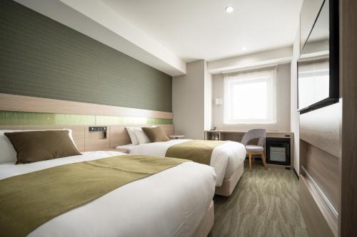 Nest Hotel Hakata Station tesisinde bir odada yatak veya yataklar