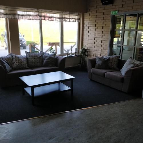 a living room with couches and a coffee table at Highway Hotel in Härnösand