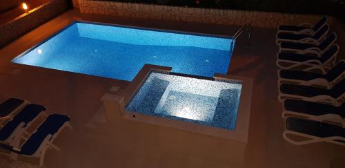 a pool of water in a room with chairs at Apartments Antonio in Cavtat