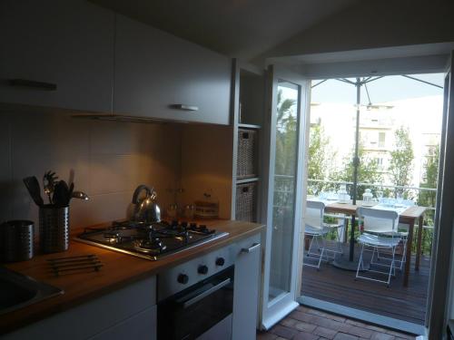 a kitchen with a stove top oven next to a balcony at BBCasablu in Acireale