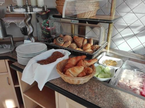 a kitchen counter with baskets of bread and other foods at Landgasthof zum Hirschenstein, Pension Garni in Sankt Englmar