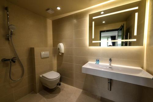 a bathroom with a sink and a toilet and a mirror at RAYA Garden - Park Hotel & Winery in Veliko Tŭrnovo