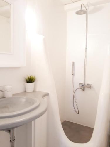 a white bathroom with a sink and a shower at Elia Sea Home in Agios Romanos