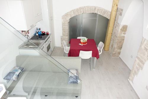 コラートにあるArco San Micheleのキッチン(赤いテーブル、白い椅子付)