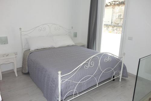 コラートにあるArco San Micheleのベッドルーム1室(グレーのベッドカバー付)、窓が備わります。