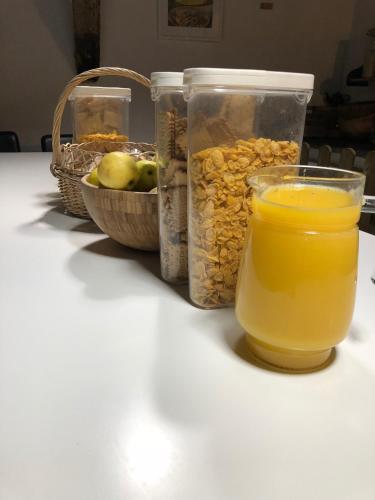 Ein Glas Orangensaft neben einem Korb mit Essen in der Unterkunft Albergue Rosalia / Pilgrim Hostel in Castrojeriz
