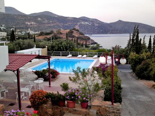a villa with a swimming pool and a view of the water at Dimitra Apartments in Agios Nikolaos